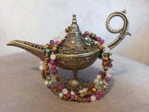 Ozdobna metalowa lampa w orientalnym stylu z nawiniętymi kolorowymi bransoletkami z kamieni naturalnych.